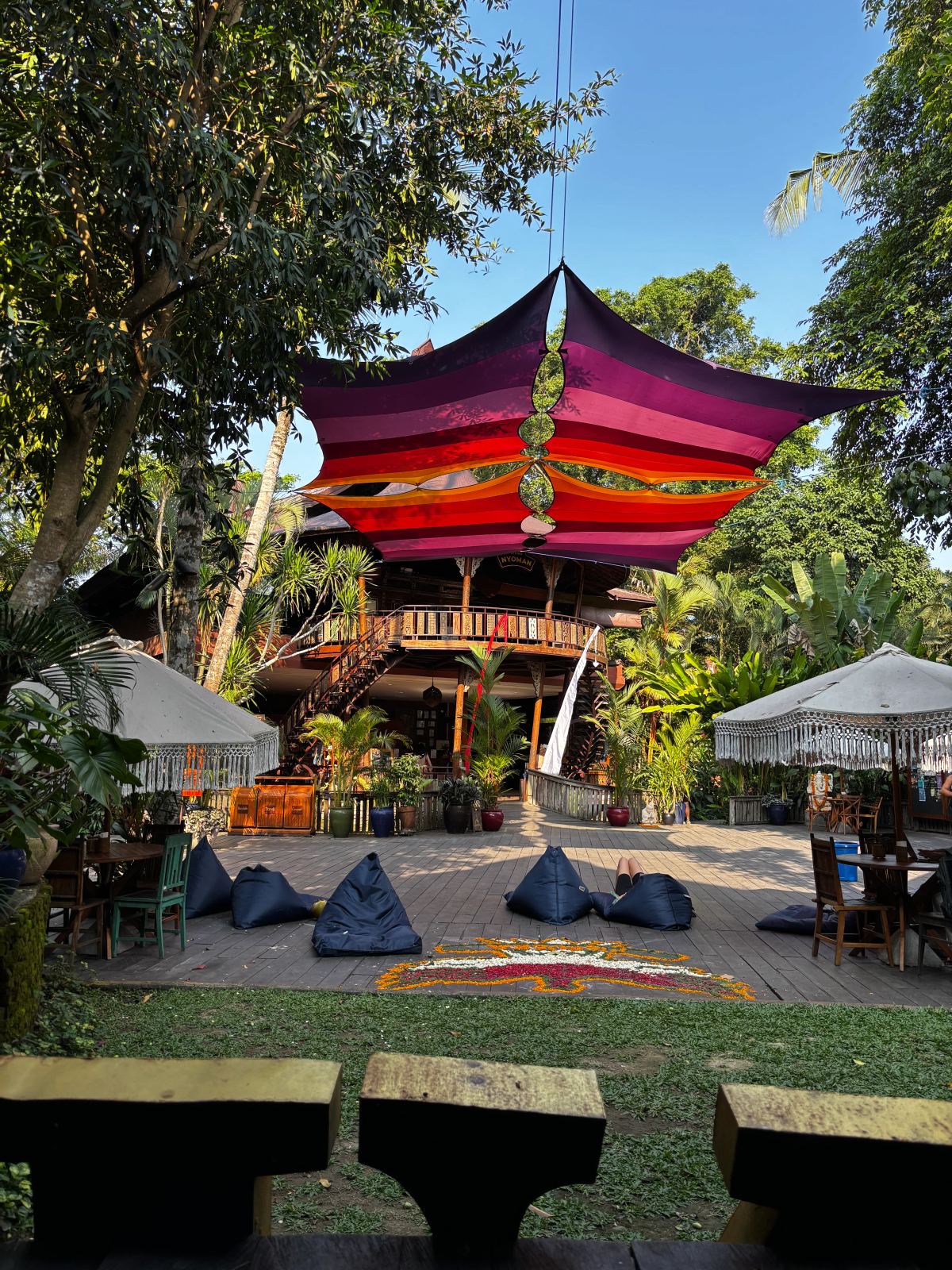 Spazio all’aperto dello Yoga Barn tra vegetazione e architetture balinesi.