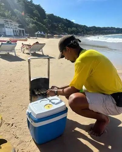 Venditore ambulante prepara queijo coalho sulla spiaggia brasiliana.