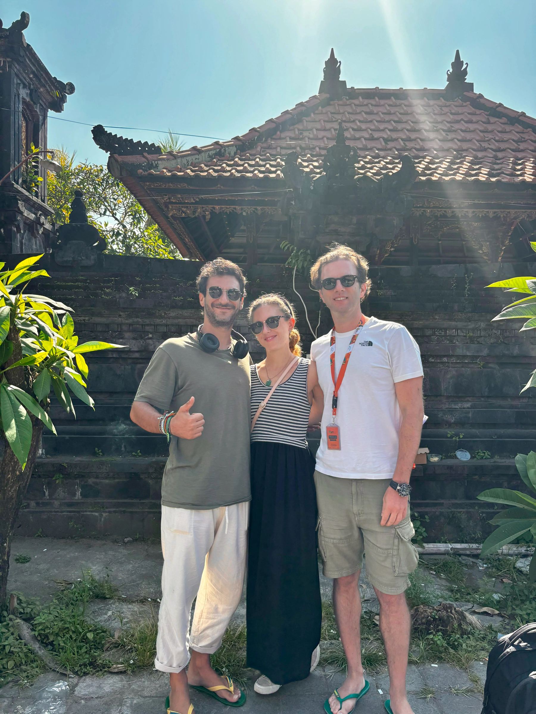 Tre viaggiatori davanti a un tempio balinese al termine del percorso.